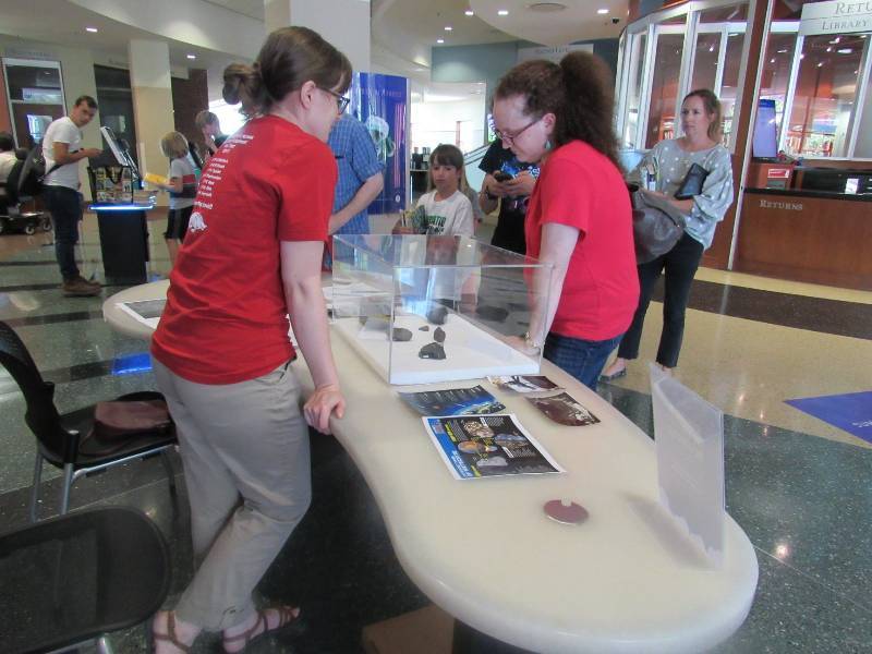 Curator Laurel Lamb sharing meteorite specimens with the public at a recent Museum in the Fayetteville Public Library event.